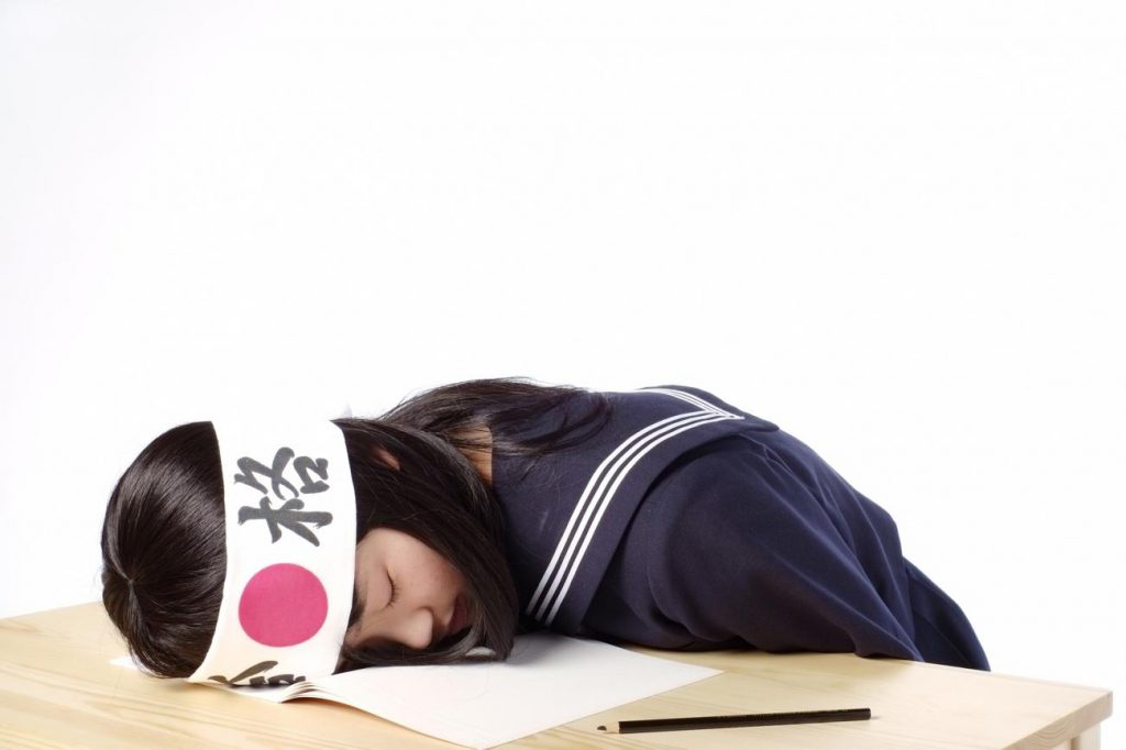勉強中に居眠りをする女子学生