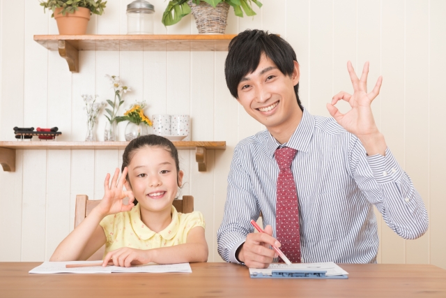 OKポーズをとる家庭教師と少女