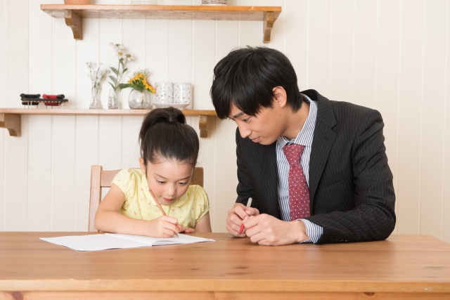 家庭教師と自宅学習する女の子